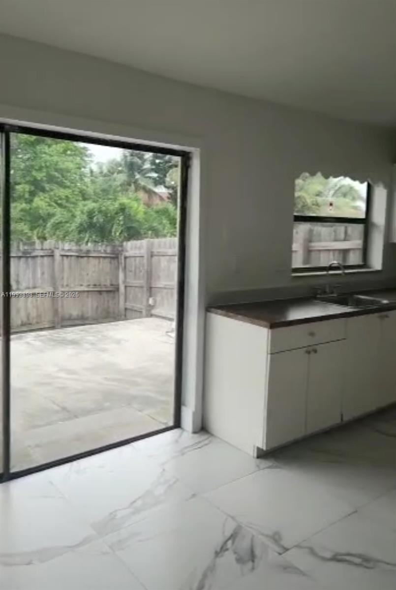13949 Southwest 281st Terrace, Unit 13949 Homestead, FL 33033 - Photo 10 of 11 a view of a kitchen with a sink and dishwasher next to a window