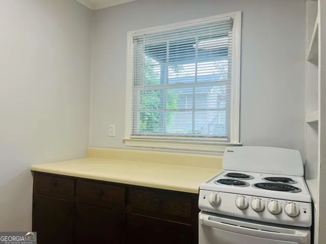 a kitchen with a stove and a white cabinet