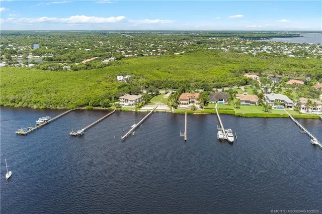 an aerial view of residential houses with outdoor space and parking