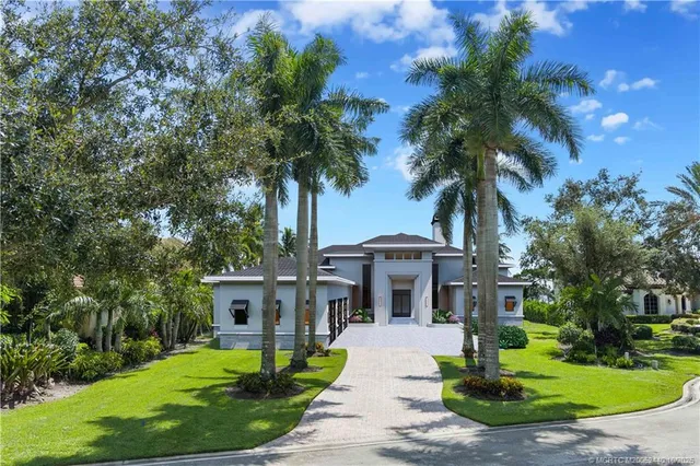 a front view of a house with a garden and trees