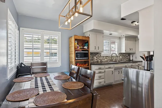 a kitchen with a table chairs stove and wooden floor