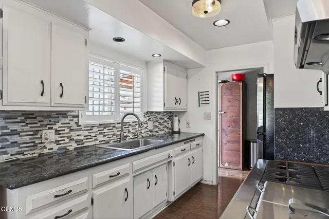 a kitchen with stainless steel appliances granite countertop a sink stove and cabinets