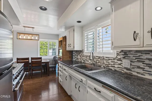 a kitchen with sink stove and cabinets