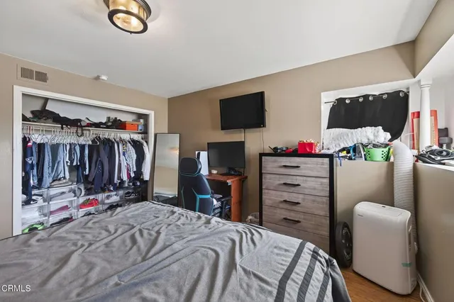 a bedroom with a bed a flat screen tv and a couch