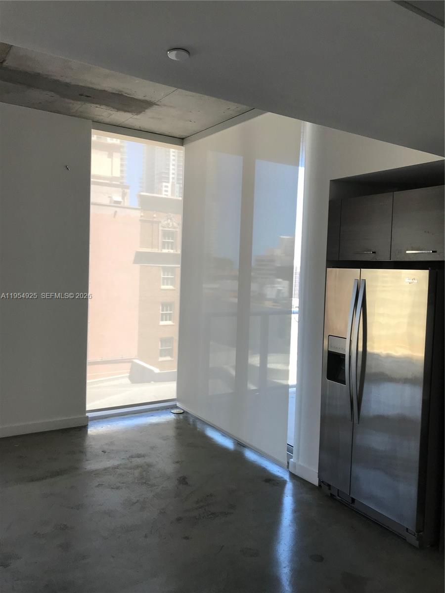 151 Southeast 1st Street, Unit 904 Miami, FL 33131 - Photo 15 of 34 a view of a refrigerator in kitchen and an empty room with wooden floor windows