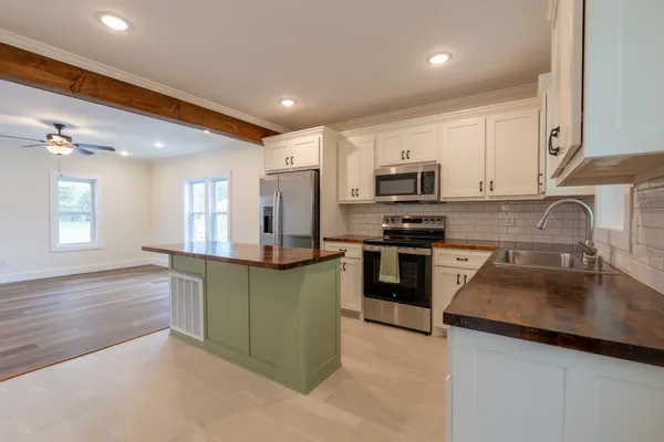 a kitchen with stainless steel appliances granite countertop a sink stove and refrigerator