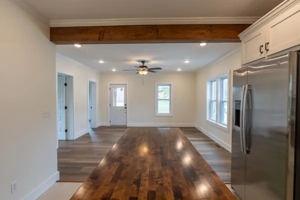 a view of hallway with a window and wooden floor