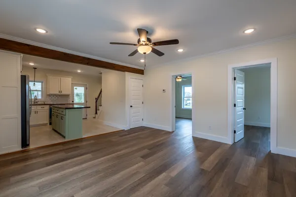 a view of a kitchen with wooden floor and a kitchen space with a sink