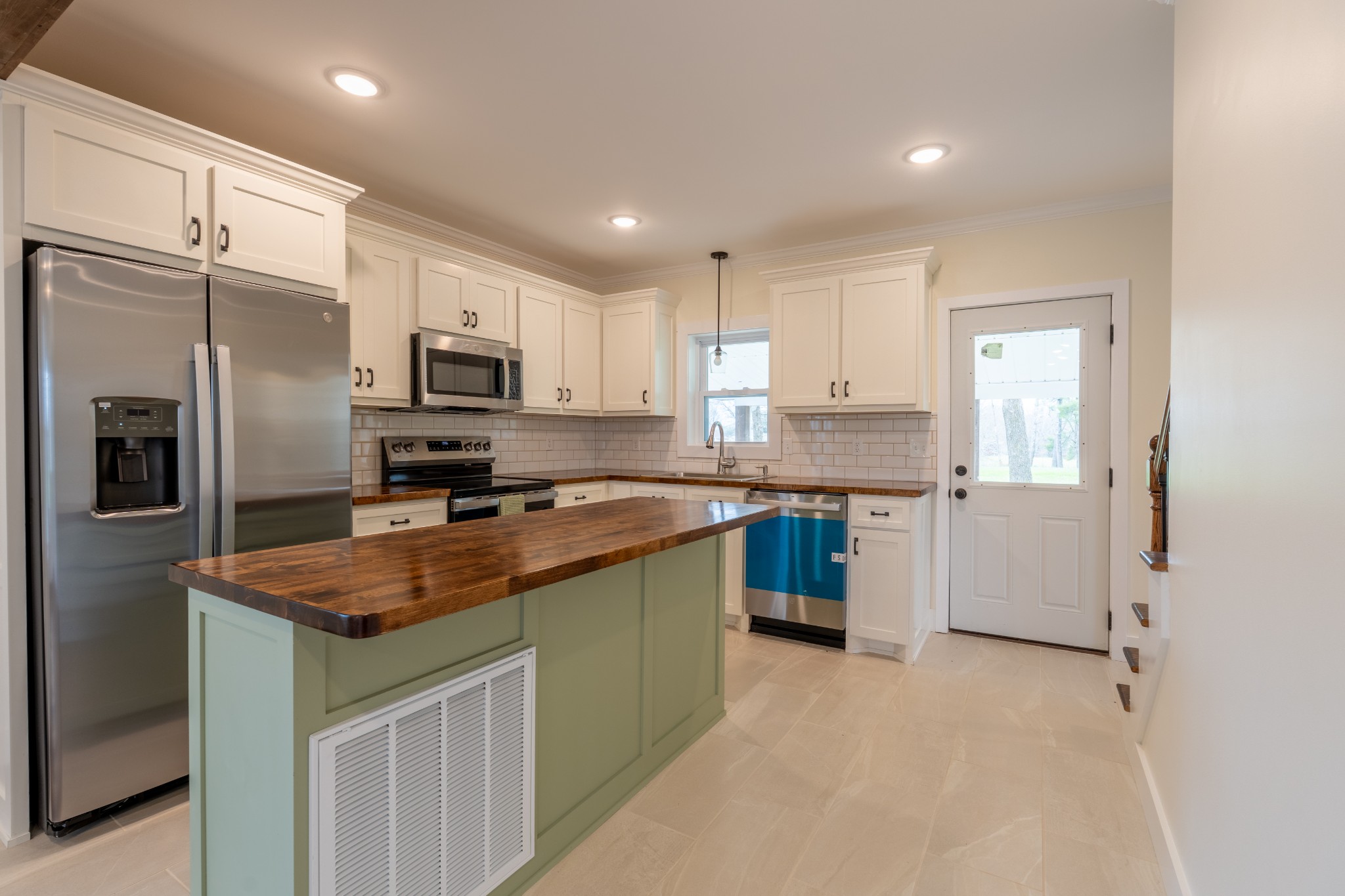 402 West Commerce Street Loretto, TN 38469 - Photo 10 of 23 a kitchen with stainless steel appliances granite countertop a refrigerator a sink a stove a microwave and island