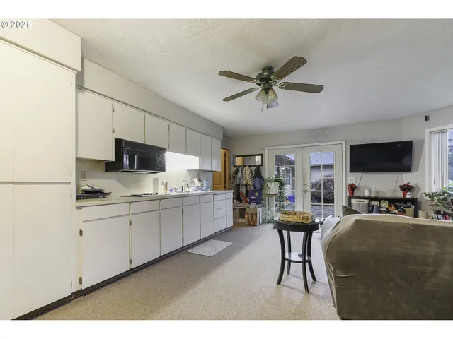 a living room with stainless steel appliances kitchen island granite countertop furniture a rug and a window