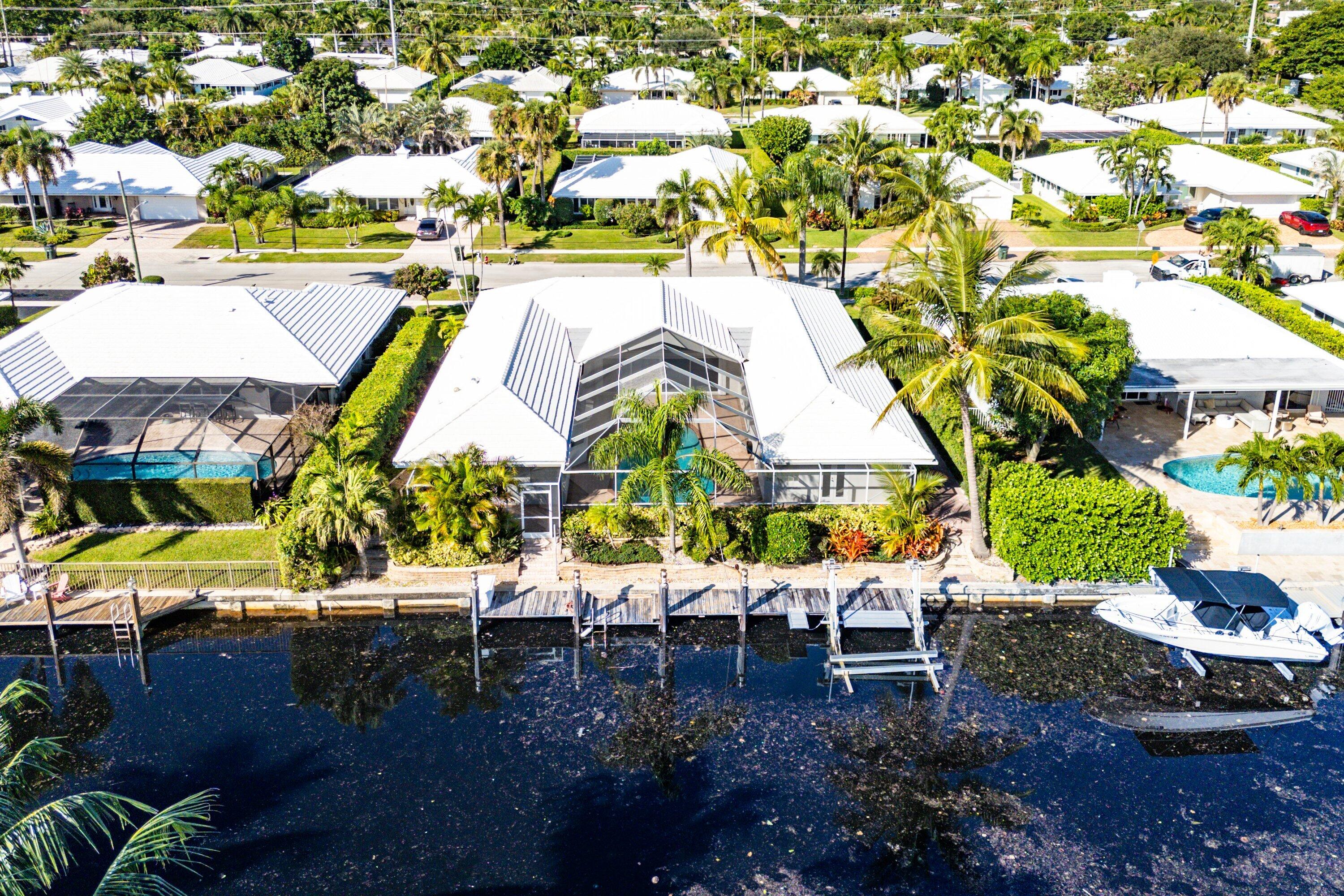 an aerial view of a house with a garden and lake view
