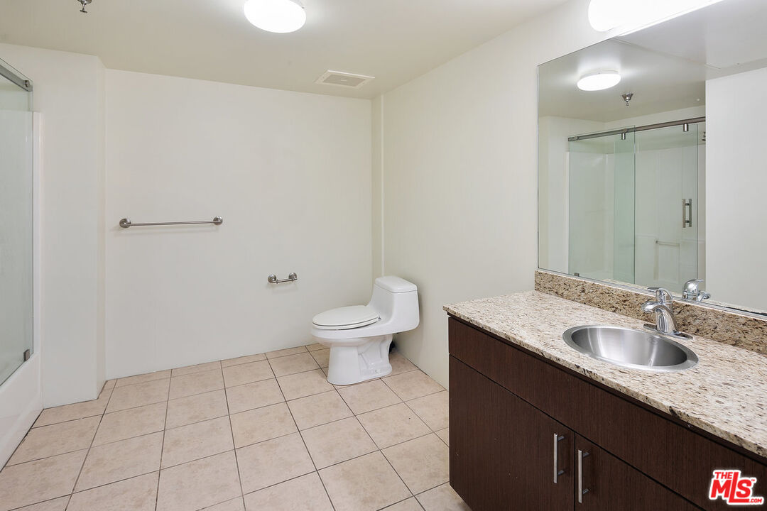200 North San Fernando Road, Unit 320 Los Angeles, CA 90031 - Photo 17 of 20 a bathroom with a granite countertop sink a toilet and a mirror