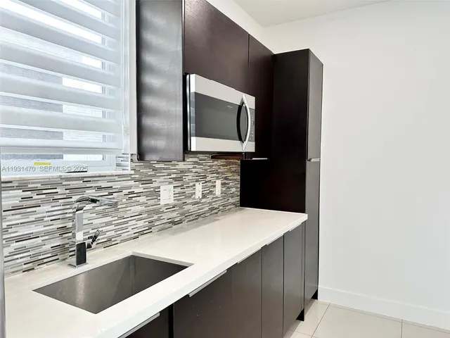 a kitchen with stainless steel appliances a sink and a microwave