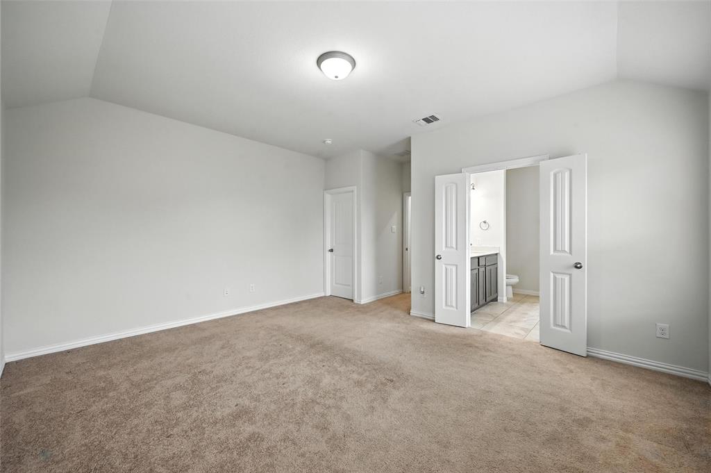 5 Pheasant Run Sanger, TX 76266 - Photo 20 of 27 Unfurnished bedroom featuring light colored carpet, lofted ceiling, and connected bathroom