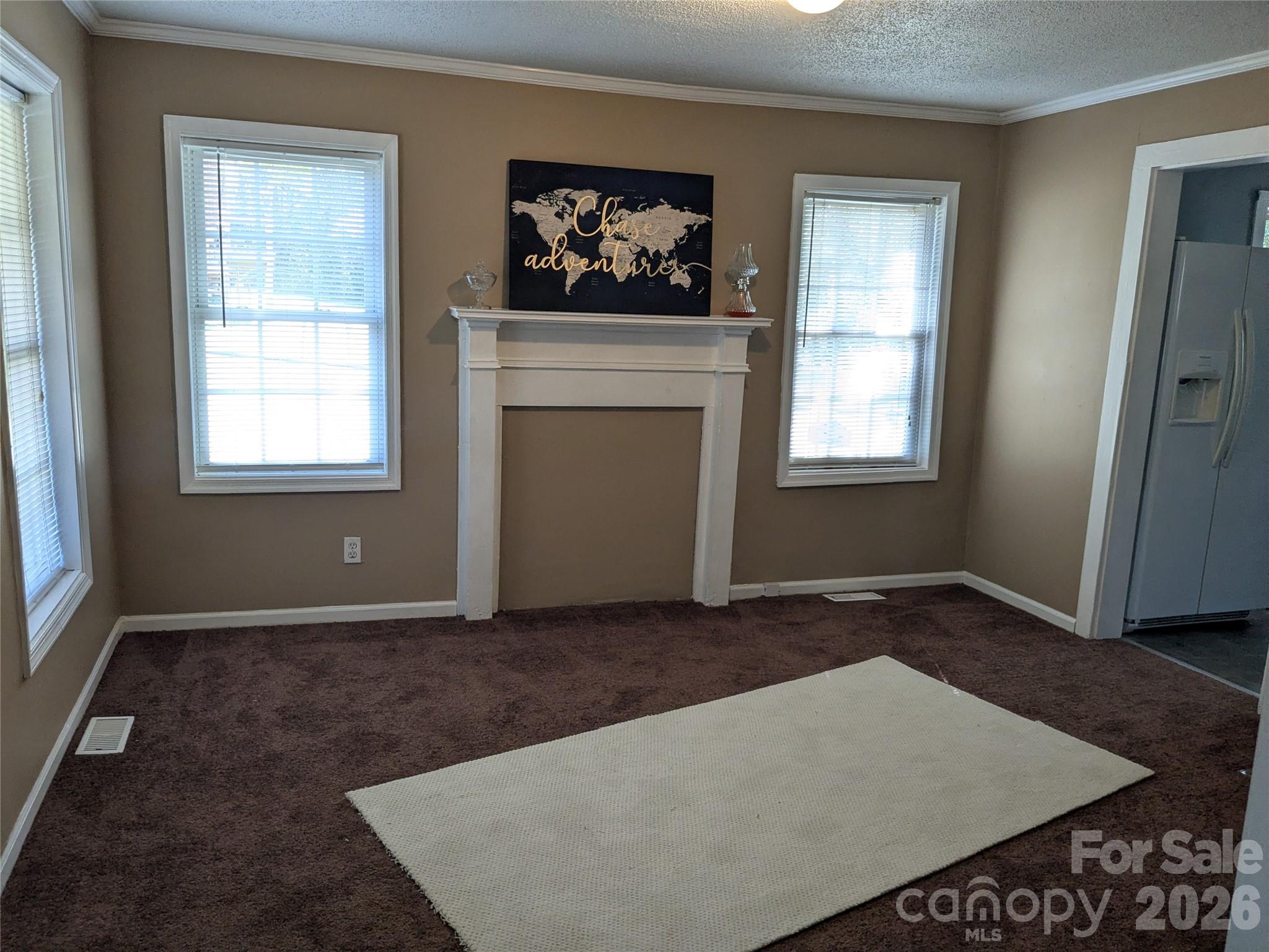 207 Morris Street Kings Mountain, NC 28086 - Photo 3 of 9 an empty room with windows and fireplace