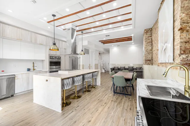a kitchen with a table chairs stove and white cabinets