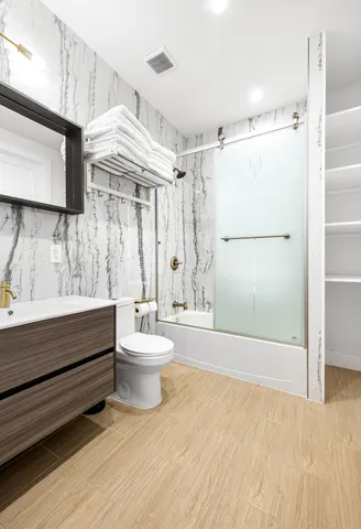 a bathroom with a sink a toilet and shower