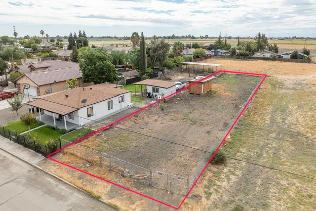 an aerial view of a house with a yard and lake view