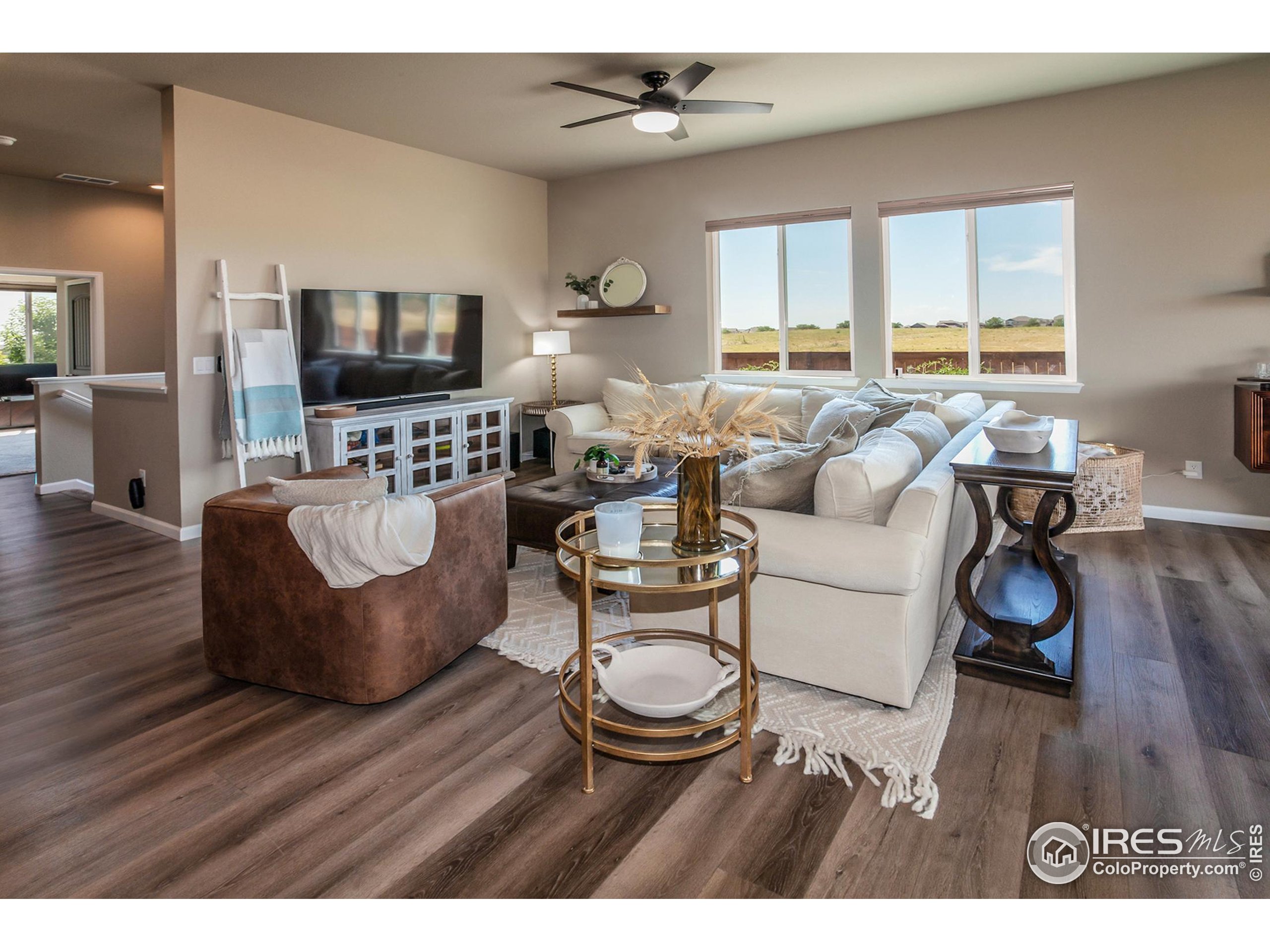 1231 105th Avenue Greeley, CO 80634 - Photo 15 of 43 a living room with furniture a flat screen tv and a large window