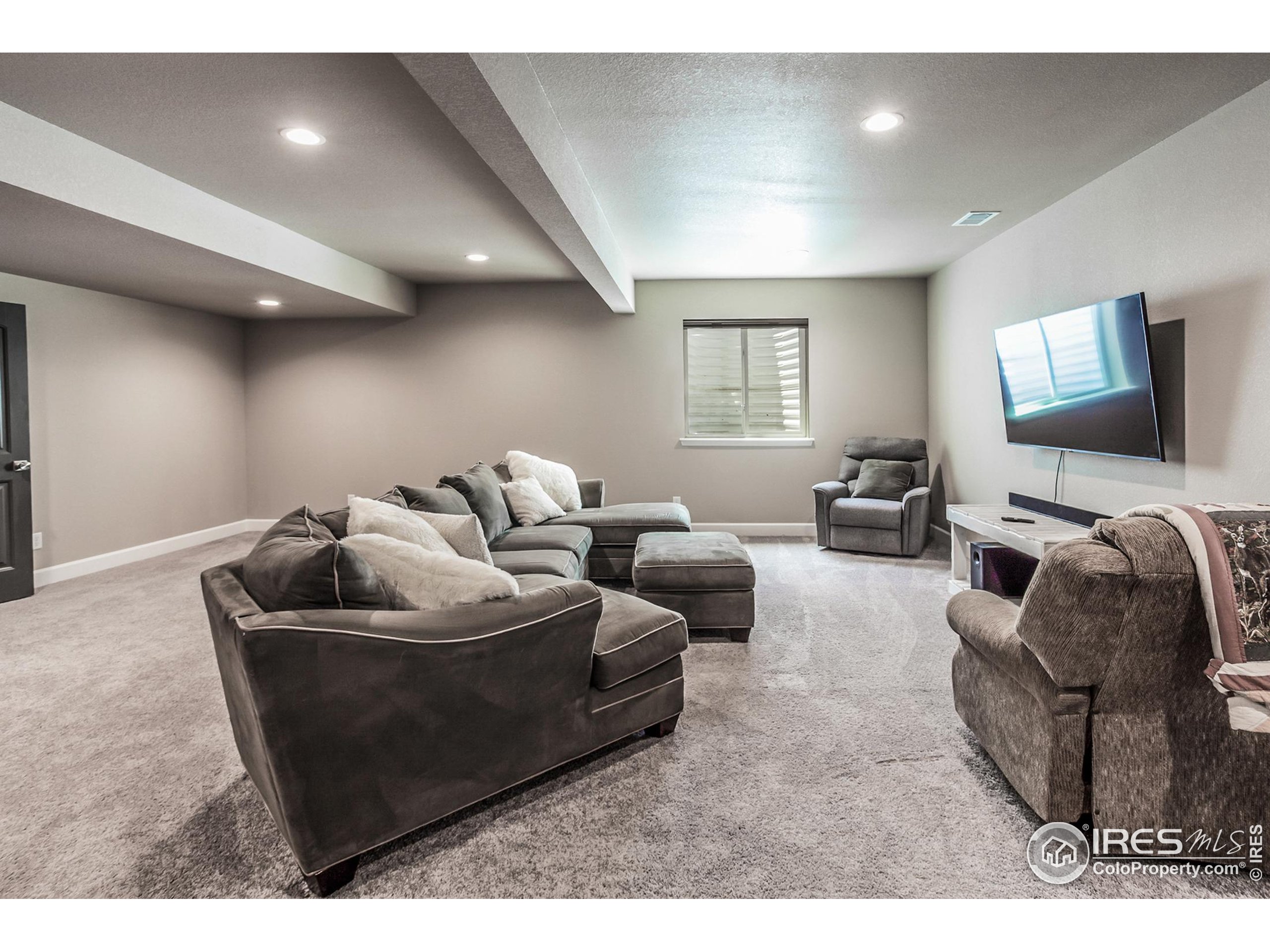 1231 105th Avenue Greeley, CO 80634 - Photo 31 of 43 a living room with furniture and a flat screen tv