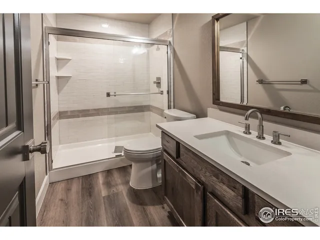 a bathroom with a granite countertop sink a mirror and shower