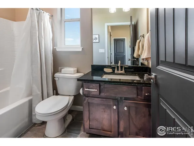 a bathroom with a granite countertop toilet sink and mirror