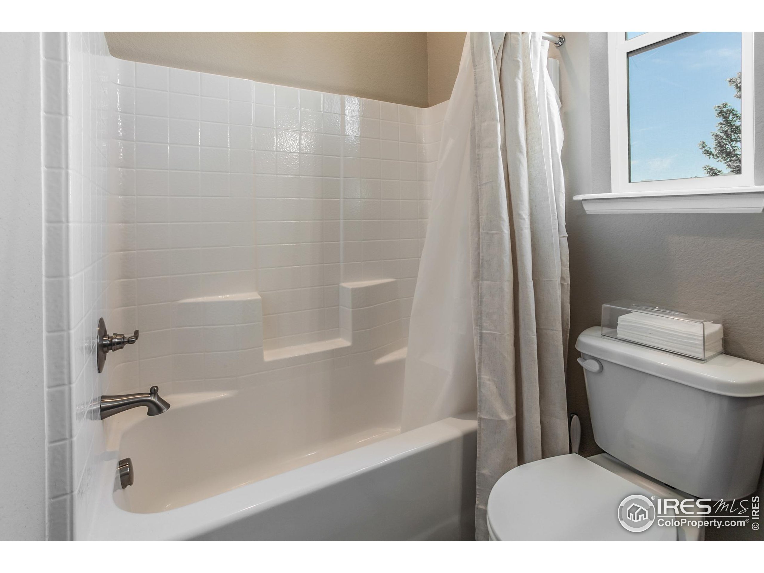 1231 105th Avenue Greeley, CO 80634 - Photo 7 of 43 a bathroom with a toilet and a shower curtain
