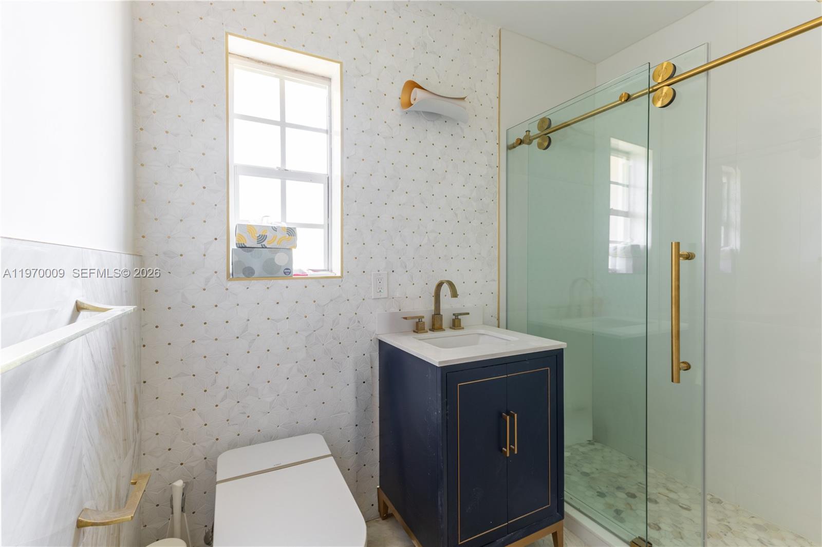 4555 Alton Road Miami Beach, FL 33140 - Photo 18 of 34 a bathroom with a sink a toilet and shower