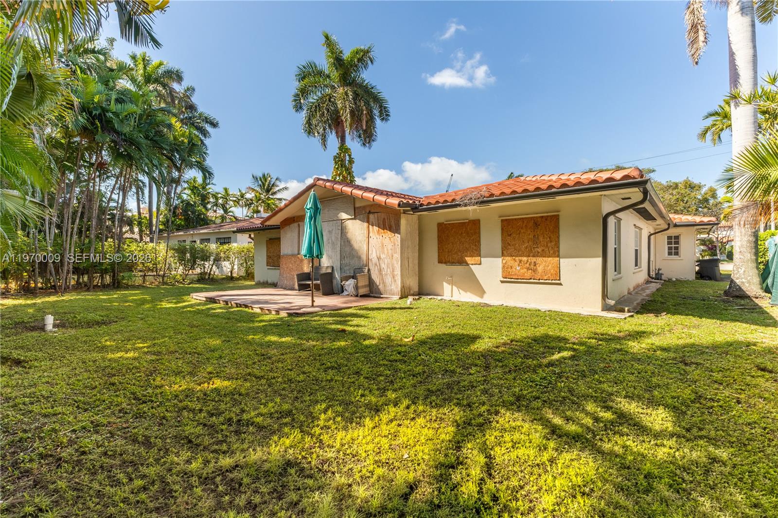 4555 Alton Road Miami Beach, FL 33140 - Photo 23 of 34 a view of a house with a swimming pool and a yard