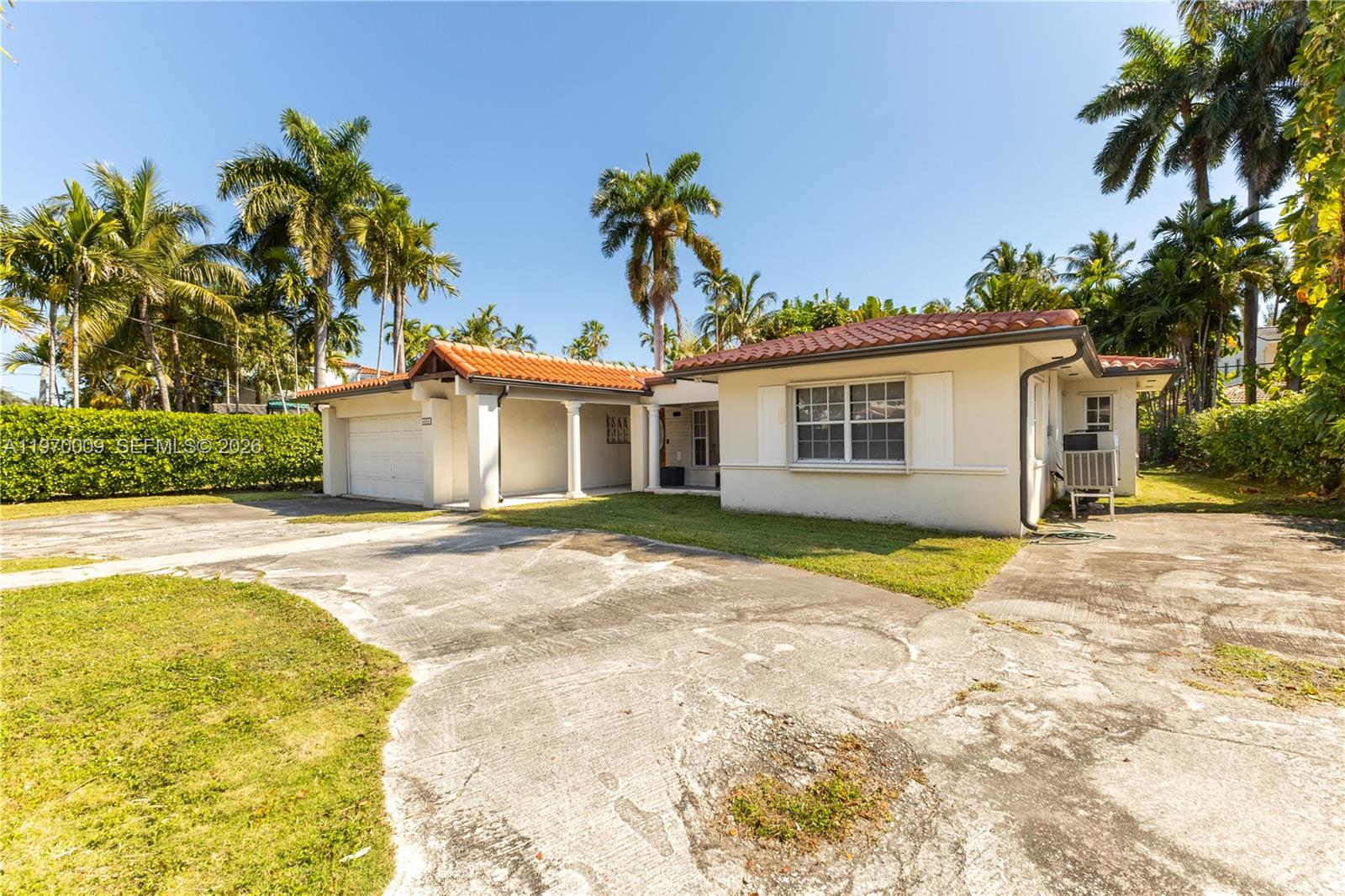 4555 Alton Road Miami Beach, FL 33140 - Photo 4 of 34 a view of a white house with a yard and palm trees