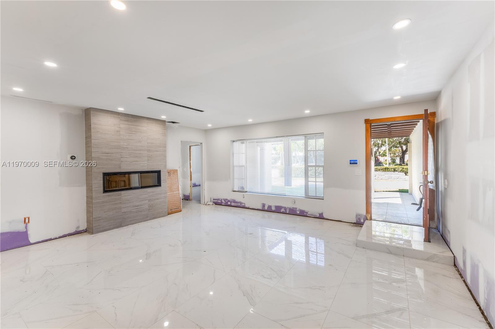 4555 Alton Road Miami Beach, FL 33140 - Photo 9 of 34 an empty room with windows and fireplace