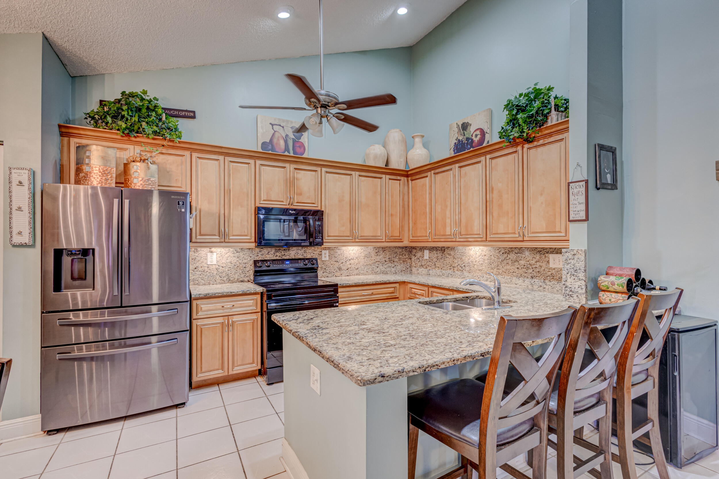 a kitchen with granite countertop a table chairs stove and refrigerator