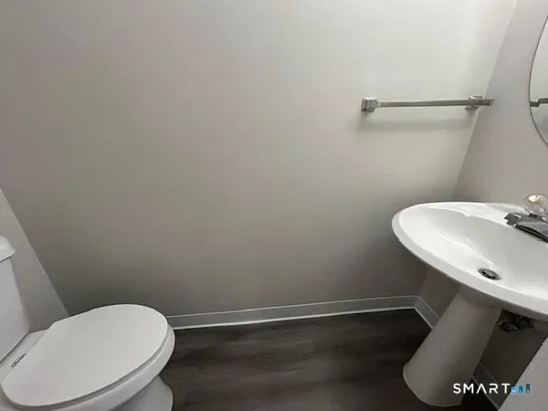 a bathroom with a toilet a sink and mirror