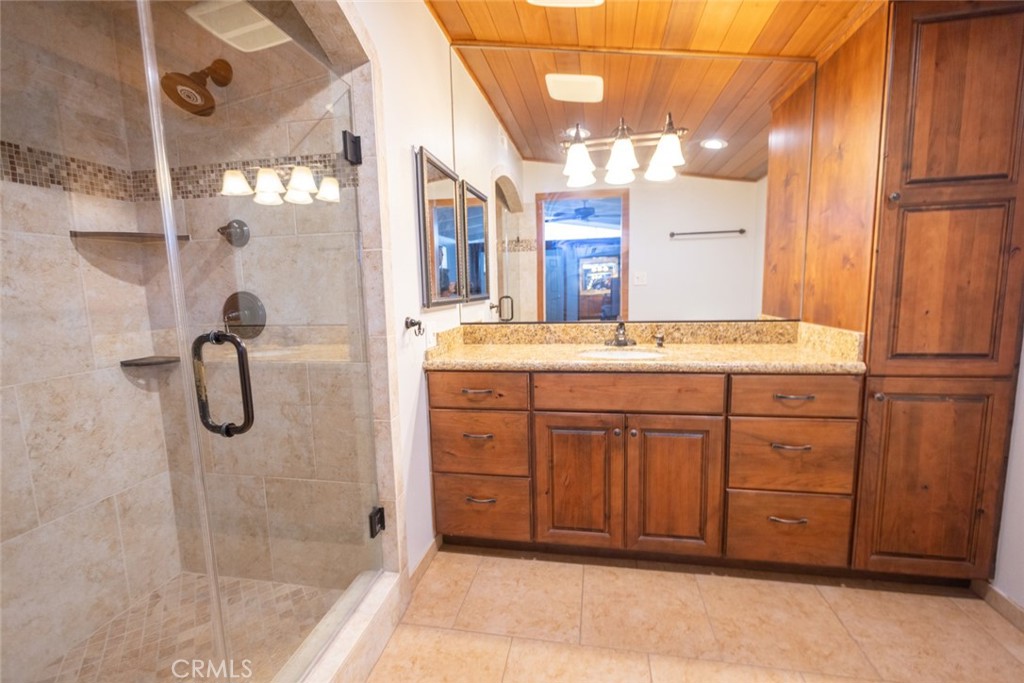14732 Candeda Place Tustin, CA 92780 - Photo 23 of 37 a bathroom with a double vanity sink a mirror and a shower