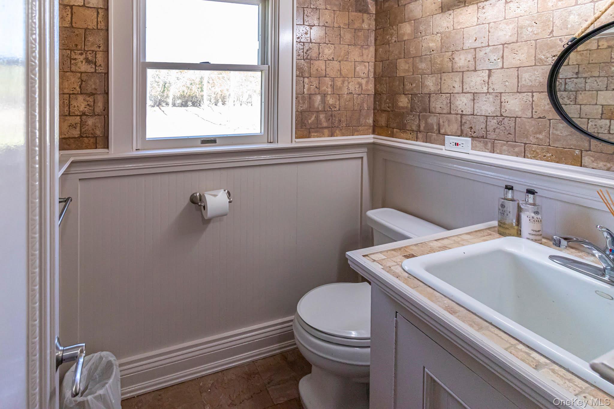6 Bayview Terrace Hampton Bays, NY 11946 - Photo 14 of 36 Half bathroom with vanity and a wainscoted wall