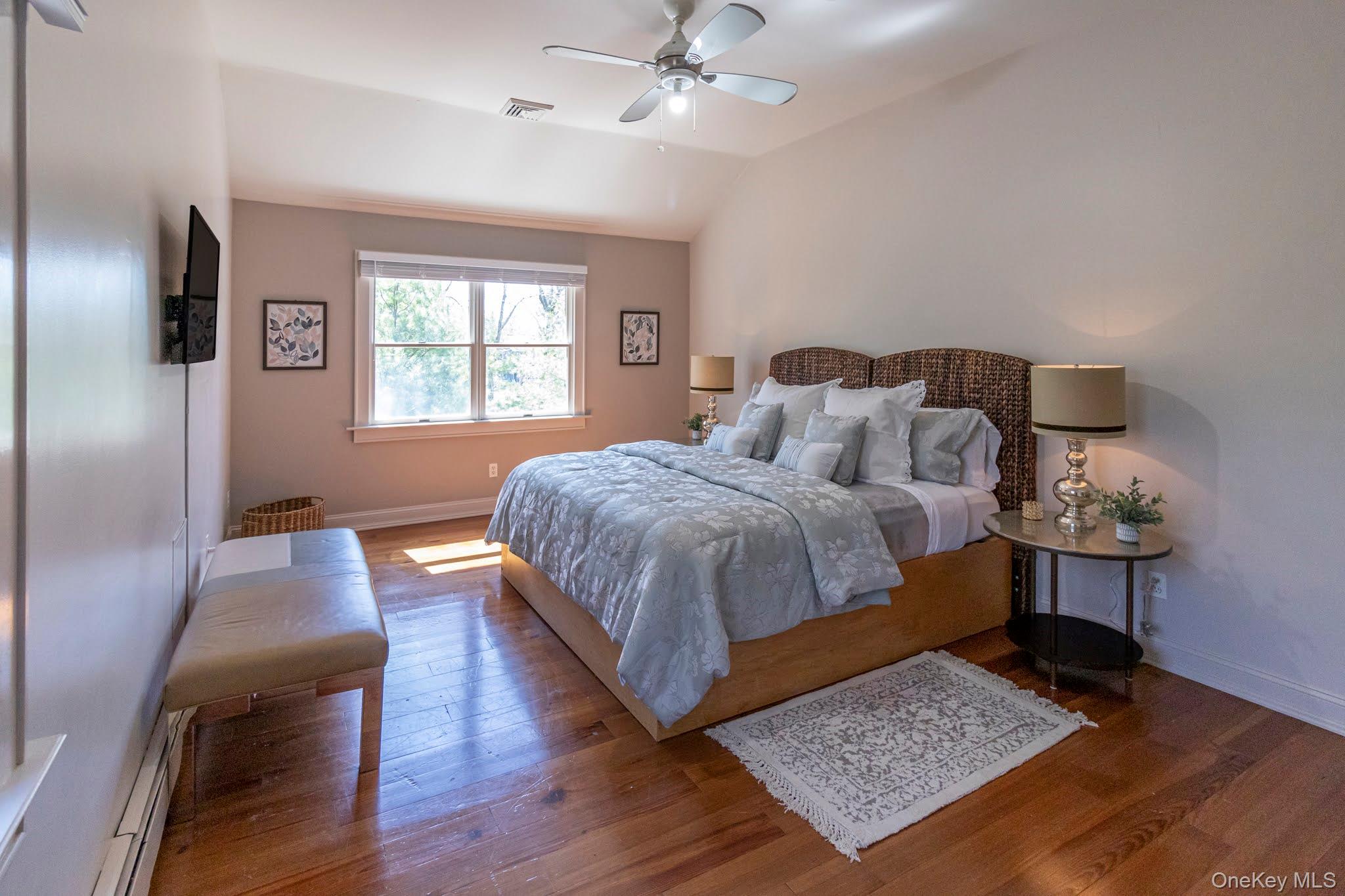 6 Bayview Terrace Hampton Bays, NY 11946 - Photo 25 of 36 Bedroom with lofted ceiling, baseboard heating, hardwood / wood-style floors, and a ceiling fan