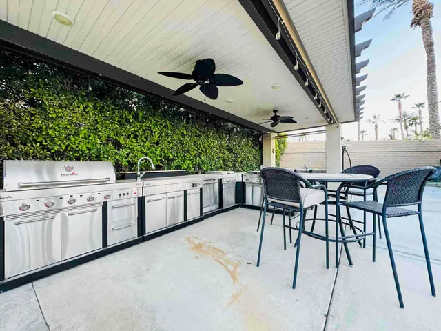 a kitchen with stainless steel appliances kitchen island granite countertop furniture and a large window
