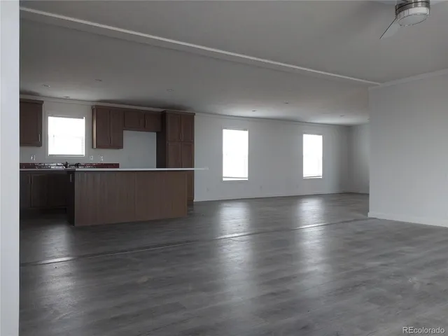 a view of an empty room with wooden floor and closet