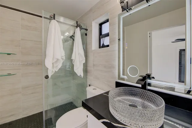 a bathroom with a sink toilet and shower