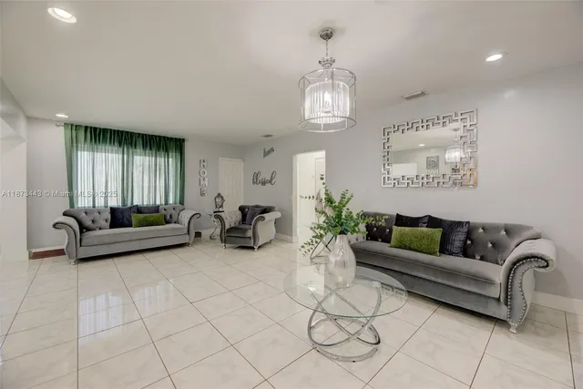 a living room with furniture and a chandelier