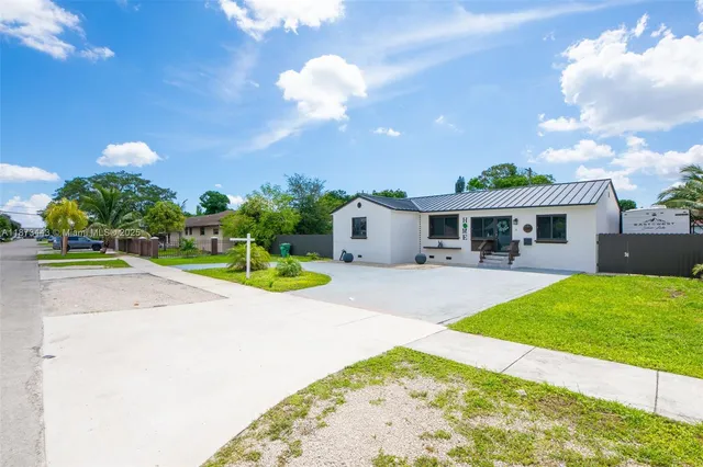 a view of a house with backyard and sitting area