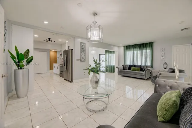 a living room with furniture a chandelier and a dining table