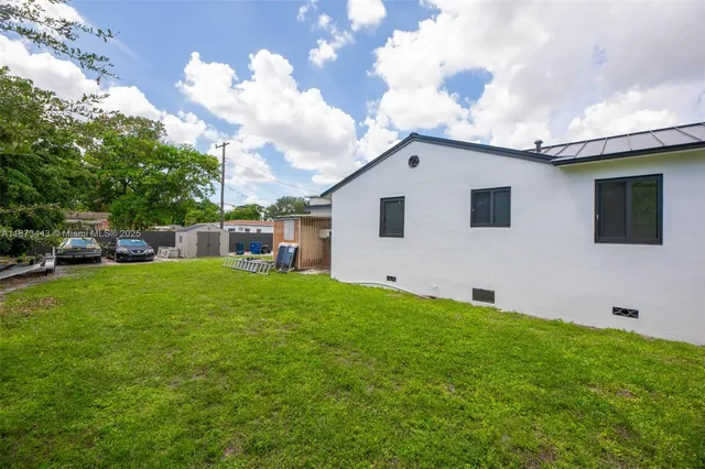 a backyard of a house with table and chairs