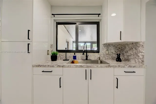 a bathroom with a granite countertop sink a vanity and a mirror