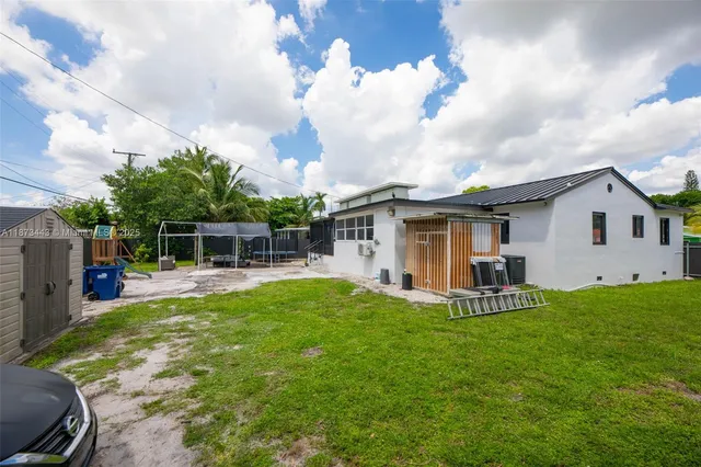 a view of a house with a yard and sitting area