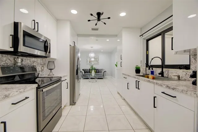 a kitchen with stainless steel appliances a sink stove and cabinets