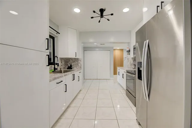 a large white kitchen with cabinets