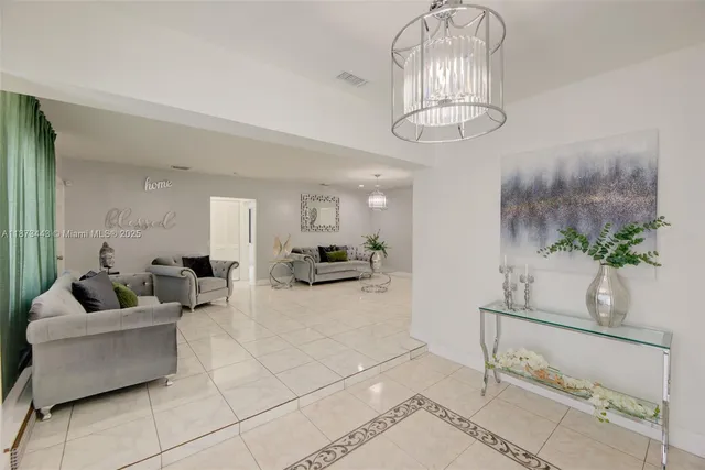 a living room with furniture and a chandelier