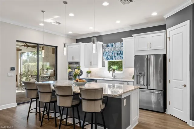 a kitchen with refrigerator a sink and chairs