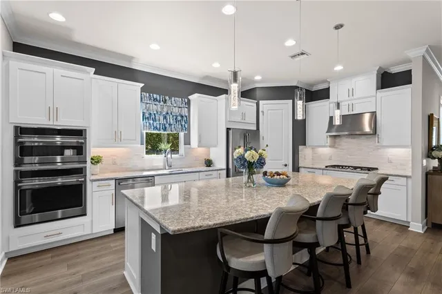 a kitchen with granite countertop a table chairs microwave and cabinets